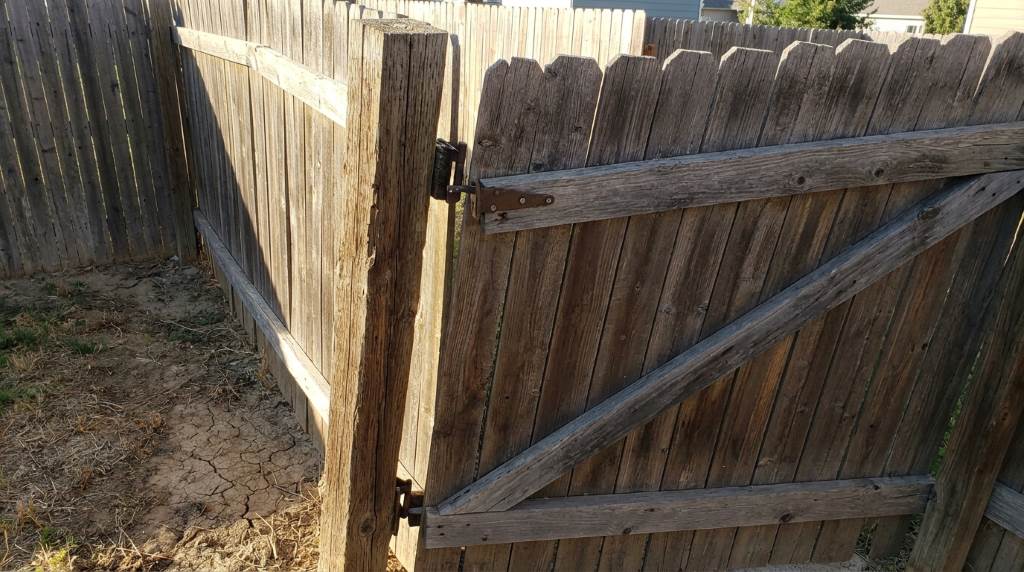 A newly leveled fence gate post with a secure concrete base